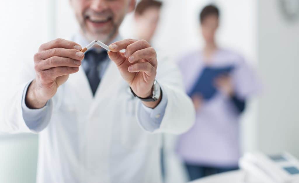 Doctor Breaking Apart a Cigarette