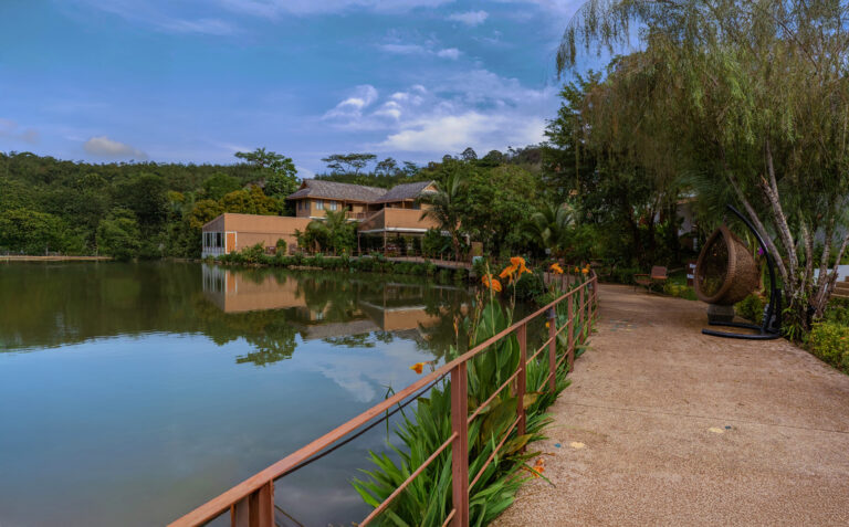 TheLifeCo Phuket beside a tranquil lake surrounded by greenery