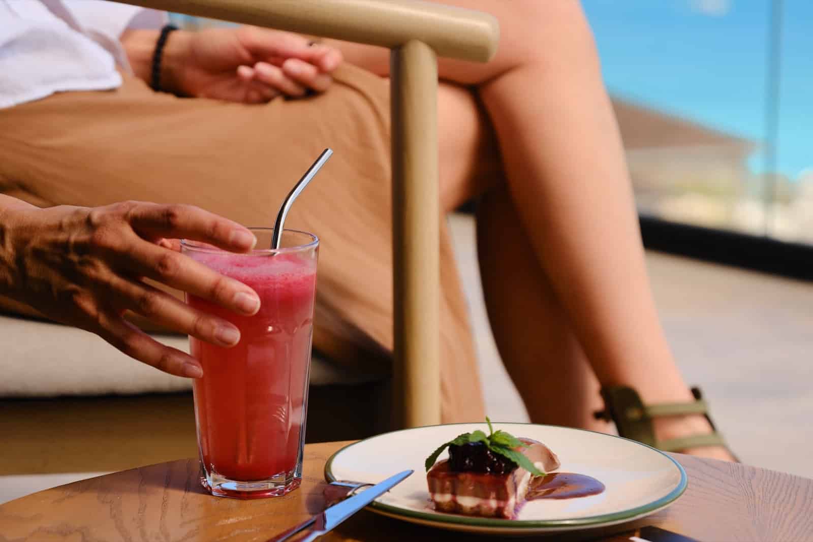 Fresh juice and a plated dish on an ocean-view terrace at TheLifeCo St. Lucia